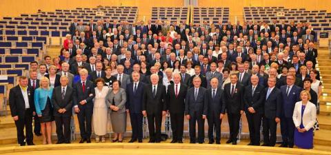 Uczestnicy konferencji  pozujący w sali to wspólnego zdjęcia