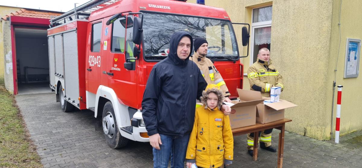 straż przy remizie rozdająca maseczki